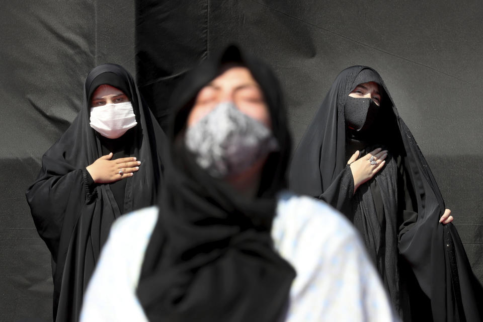 Women wearing protective face masks to help prevent spread of the coronavirus mourn during an annual ceremony commemorating Ashoura at the Saleh shrine in northern Tehran, Iran, Sunday, Aug. 30, 2020. Ashoura is the anniversary of the 7th century death of Imam Hussein, a grandson of Prophet Muhammad, and one of Shiite Islam's most beloved saints, who was killed in a battle in Karbala in present-day Iraq. (AP Photo/Ebrahim Noroozi)