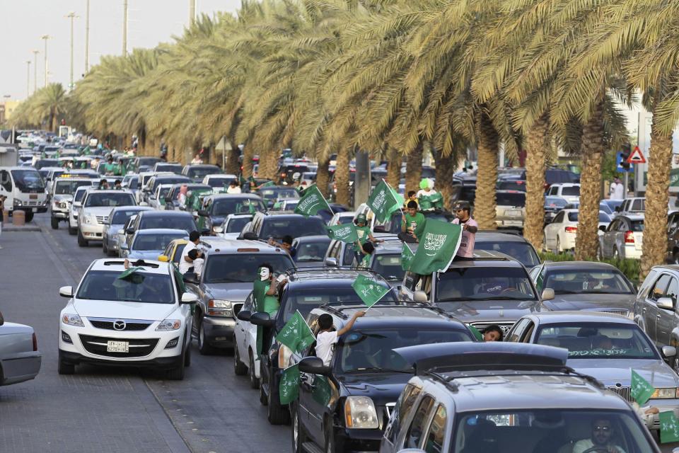 Boys wave Saudi Arabia's national flag as they ride a car, as the oil-rich Gulf Arab country celebrates its National Day, in Riyadh September 23, 2013. REUTERS/Faisal Al Nasser (SAUDI ARABIA - Tags: POLITICS ANNIVERSARY)