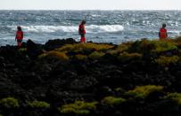 Rescue workers search for bodies after a boat with 46 migrants from the Maghreb region capsized in the beach of Orzola