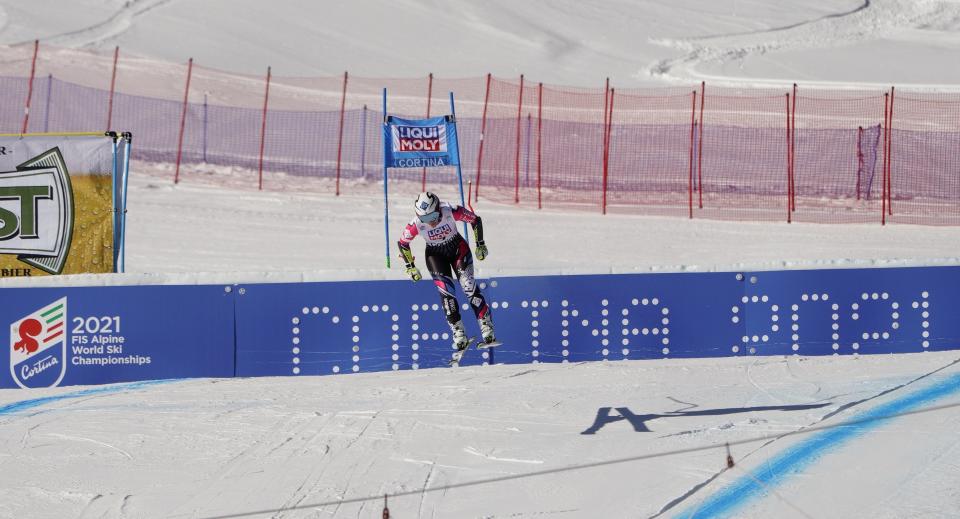 FILE - In this Jan. 20, 2019 file photo, Liechtenstein's Tina Weirather speeds down the course as a banner advertising the ski world championships in Cortina d’Ampezzo is seen in the background, during an alpine ski, women's World Cup super-G in Cortina D'Ampezzo, Italy. The Italian Winter Sports Federation (FISI) announced Sunday, May 24, 2020 that it would like to postpone next year’s Alpine skiing world championships in Cortina until March 2022 in order to avoid the championships being canceled or shortened due to the fallout in Italy from the coronavirus pandemic. (AP Photo/Giovanni Auletta, file)