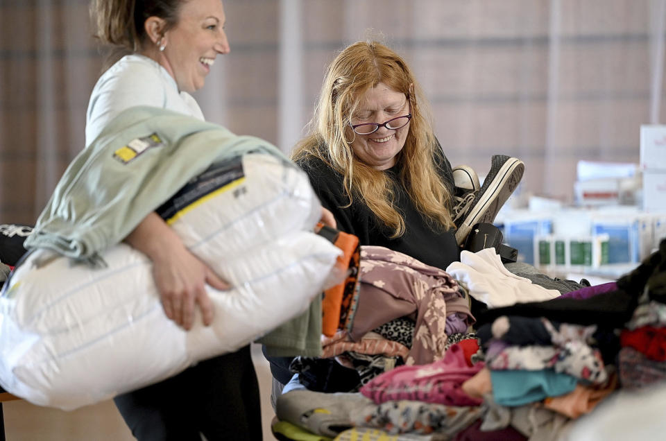 Pam Browne, right, laughs with volunteer Jamie Martin, as they pick out clothing at the Sullivan Community Center, Sunday, April 2, 2023, in Sullivan, Ind., after a tornado moved through the area late Friday. (Joseph C. Garza/The Tribune-Star via AP)