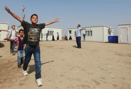 Children of Iraqi Kawliya group (known as Iraqi gypsies) play outside a school in al-Zuhoor village near the southern city of Diwaniya, Iraq April 16, 2018. Picture taken April 16, 2018. REUTERS/Alaa Al-Marjani