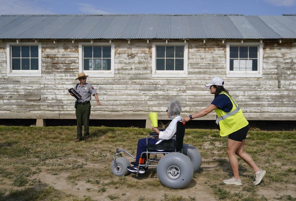 Kurt Ikeda, Director of Interpretation and Education at Minidoka National Historic Site, brings his small Minidoka Pilgrimage tour, including Mabel Tomita, center, and volunteer Tessa Fujisaki, right, to an original barracks at the Minidoka National Historic Site, Saturday, July 8, 2023, in Jerome, Idaho. (AP Photo/Lindsey Wasson)