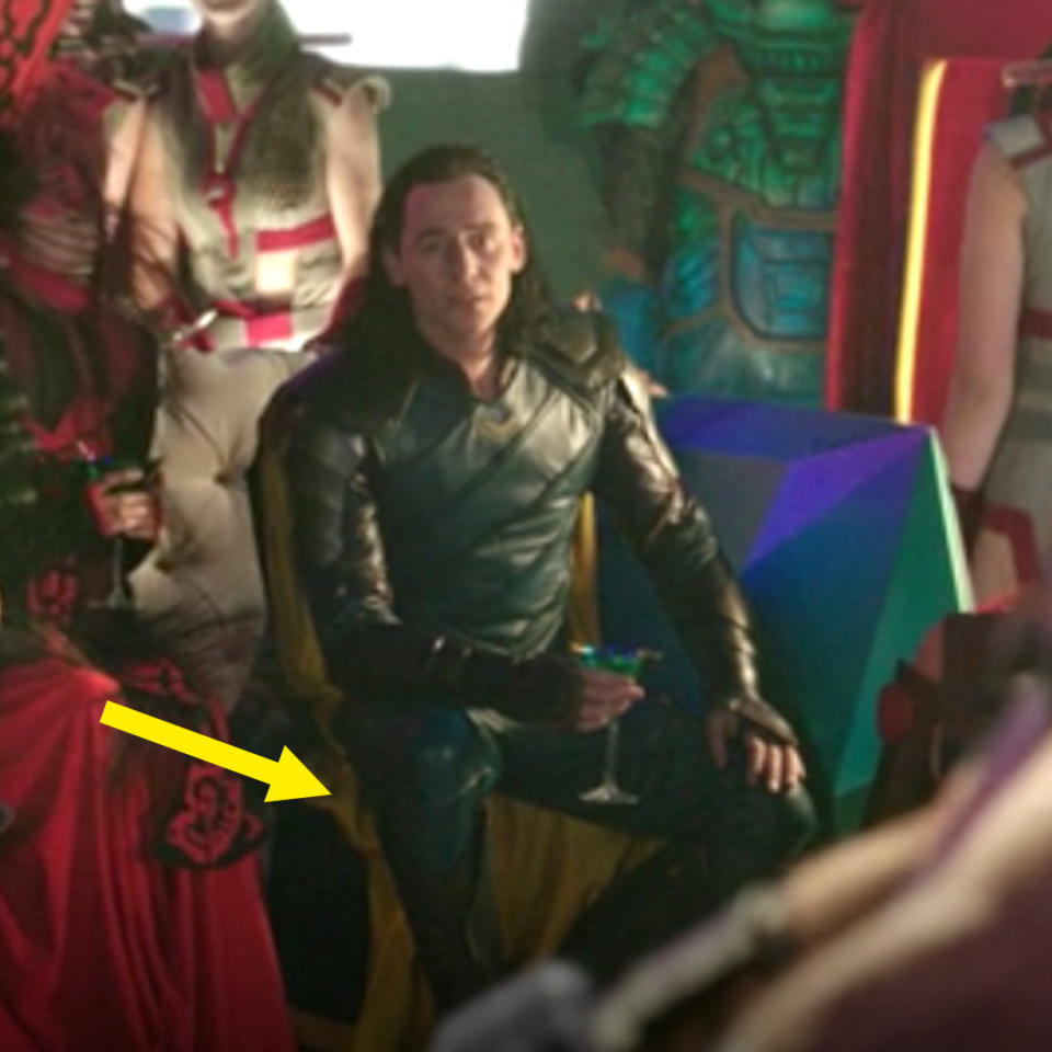 Loki sitting in the Grandmaster's palace, his cape showing bright yellow on the underside
