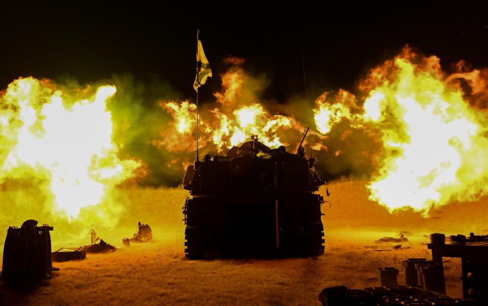 An Israel Defense Forces (IDF) artillery unit, using a self-propelled artillery howitzer, fires towards Gaza