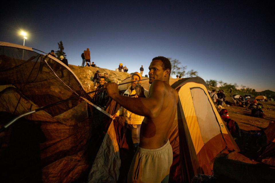 Venezuelan migrants set up an encampment on the south bank of the Rio Grande in Juárez. Many of the migrants have been expelled under Title 42 after seeking asylum and are hoping to be accepted as refugees in the U.S. In this photo, a group of men set up a large tent.