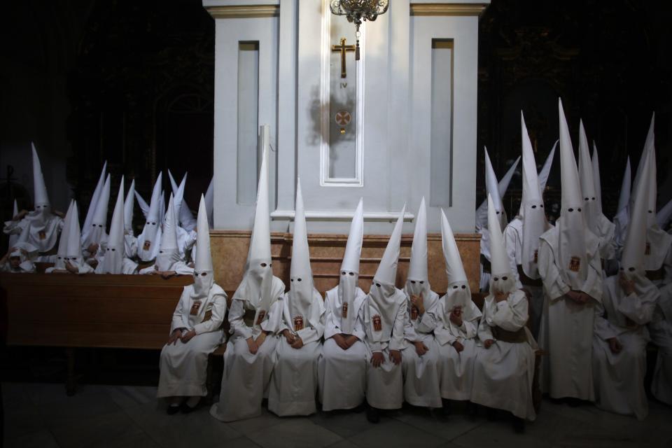 Penitents wait inside a church before taking part in the "Humildad" brotherhood's Palm Sunday procession in Malaga