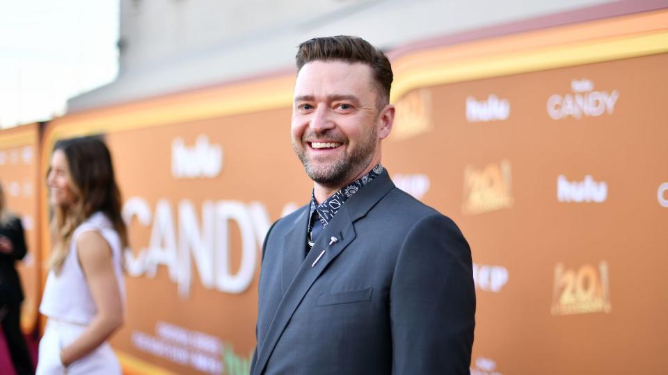 justin timberlake turning to his left and smiling for photographers taking pictures