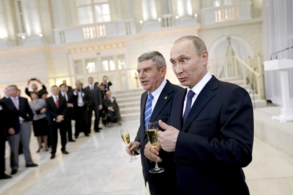 Russian President Vladimir Putin, right, and International Olympic Committee President Thomas Bach greet IOC members at a welcoming event ahead of the 2014 Winter Olympics at the Rus Hotel, Tuesday, Feb. 4, 2014, in Sochi, Russia. (AP Photo/David Goldman, Pool)