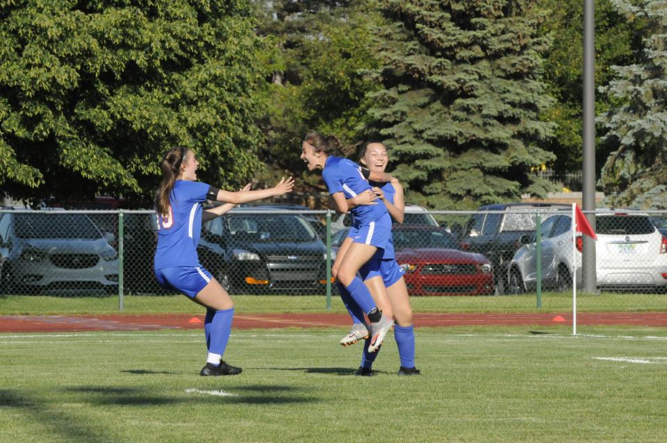 Lenawee Christian's Janae Good (middle), Kylie Summer (right) and Olivia Durbin (left) celebrate a goal during Thursday's Division 4 district championship against Manchester.