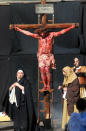 Portraying Jesus Christ a man takes part in a Way of the Cross procession, at the St. Isidoro Agricola church in Palermo, Sicily, Friday, April 18, 2014. Holy Week commemorates the last week of the earthly life of Jesus Christ culminating in his crucifixion on Good Friday and his resurrection on Easter Sunday. (AP Photo/Alessandro Fucarini)