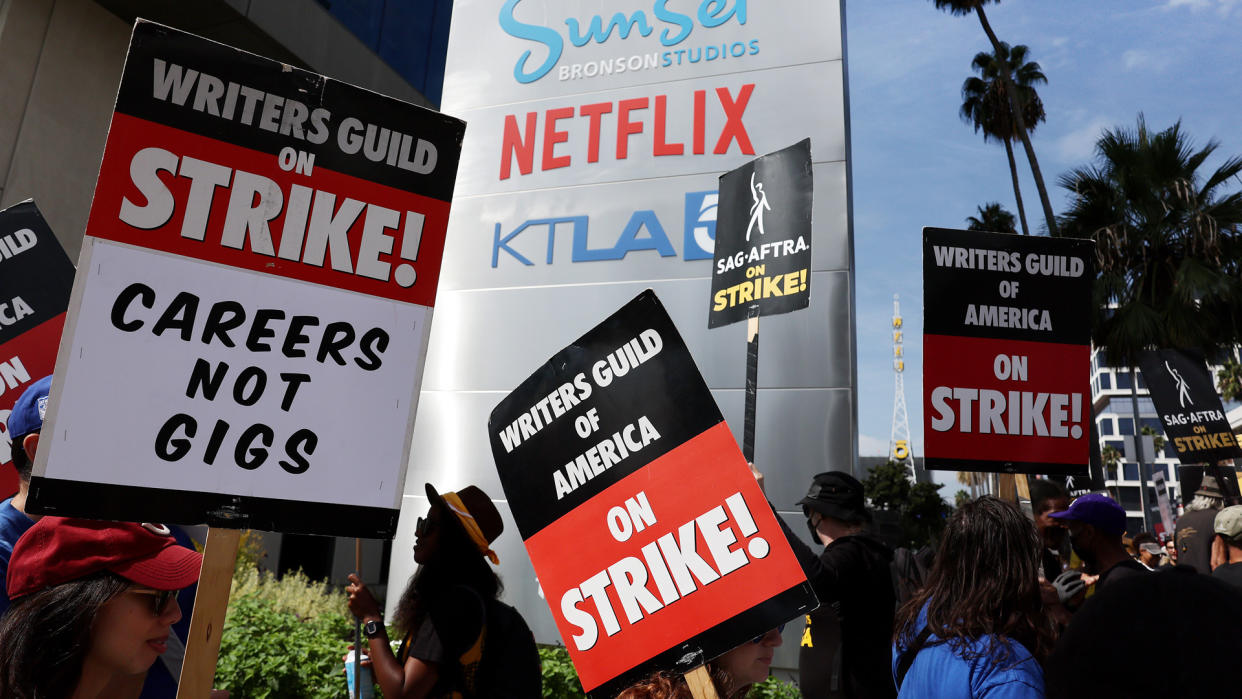  An image of striking writers' placards being held in front of Netflix's LA-based studio. 