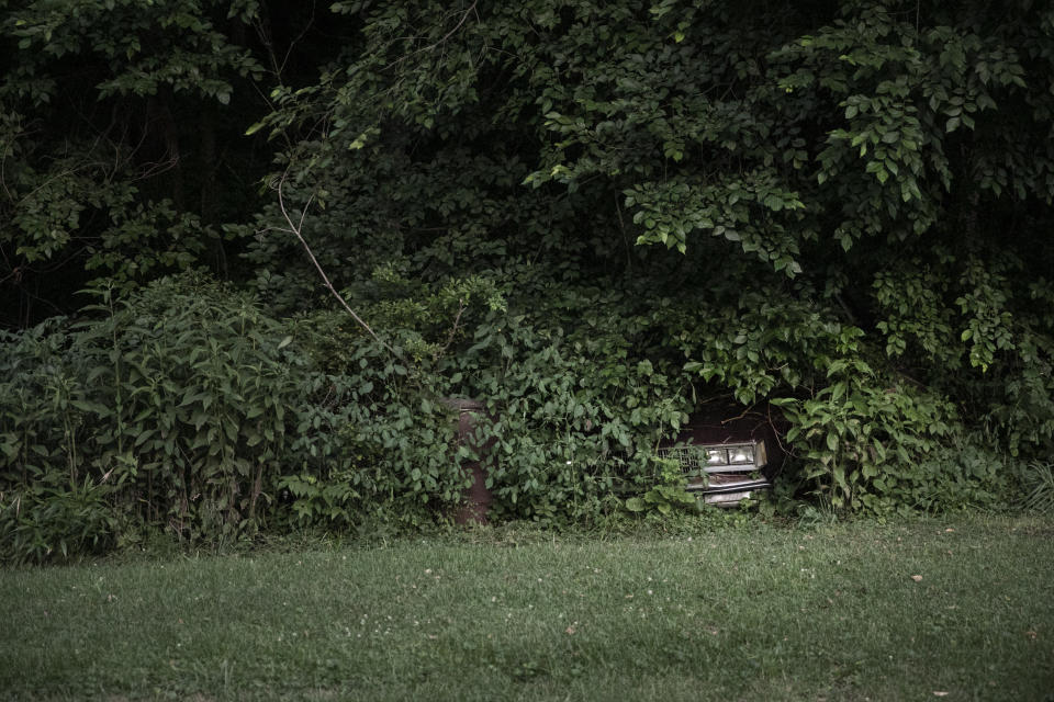 The headlights of an abandoned car peek through an overgrowth of vines and shrubs in Rendville, Ohio, on Sunday, July 26, 2020. Unemployment skyrocketed to highs of nearly 18 percent amid early virus shutdowns, doubling in some counties from March to April. While those rates have come down since, nearly every county in the region is still worse off than at the start of the year. (AP Photo/Wong Maye-E)