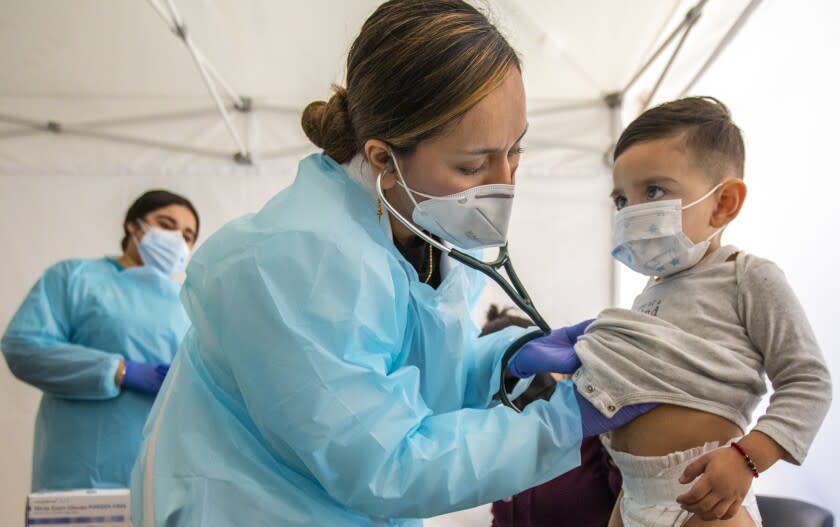 LOS ANGELES, CA - JANUARY 27: (Editor's note: This photo is initially for a Hayley Smith story.) Dr. Faraiba Faqeerzada PA-C (FP), left, examines two year Benjamin Salazar at South Central Family Health Center on Thursday, Jan. 27, 2022 in Los Angeles, CA. The center is located in a neighborhood with the highest Omicron case rates in the county. Benjamin has been having an upset stomack the last few days and his mother brought him in to get checked out. (Francine Orr / Los Angeles Times)