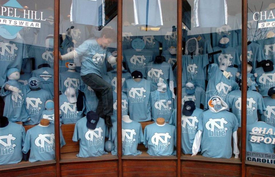 TARHEEL1.NE.SP.020504.TEL: Chapel Hill Sportswear employee Anne Frautschi helps decorate a window display Thursday, Feb. 4, 2004 at the store on Franklin St. in Chapel Hill. Profits from the “turn it blue” t-shirts will benefit charity.