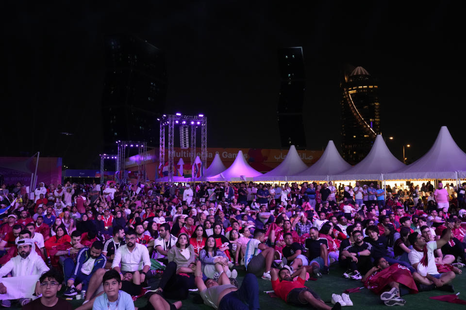 Qatar soccer fans watch in a giant screen showing the World Cup, group A soccer match between Qatar and Ecuador at Hayya Fan Zone, in Lusail, outside of Doha, Qatar, Sunday, Nov. 20, 2022. (AP Photo/Lee Jin-man)