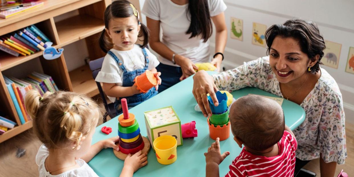 children playing a daycare with teacher - childcare costs by state