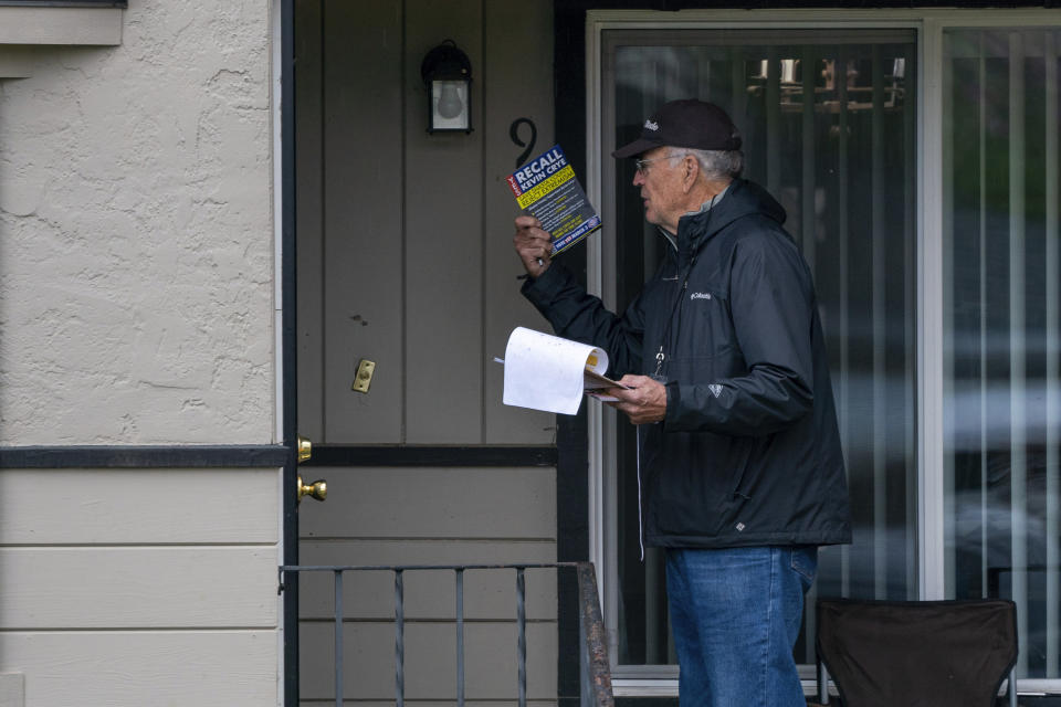 Charlie Menoher, one of the organizers of the recall of Shasta County Supervisor Kevin Crye, talks to a resident while walking a precinct in Redding, Calif., on Tuesday, Feb. 20, 2024. Crye is one of the board members who voted to get rid of the county's ballot-counting machines in favor of counting ballots by hand. (AP Photo/Rich Pedroncelli)