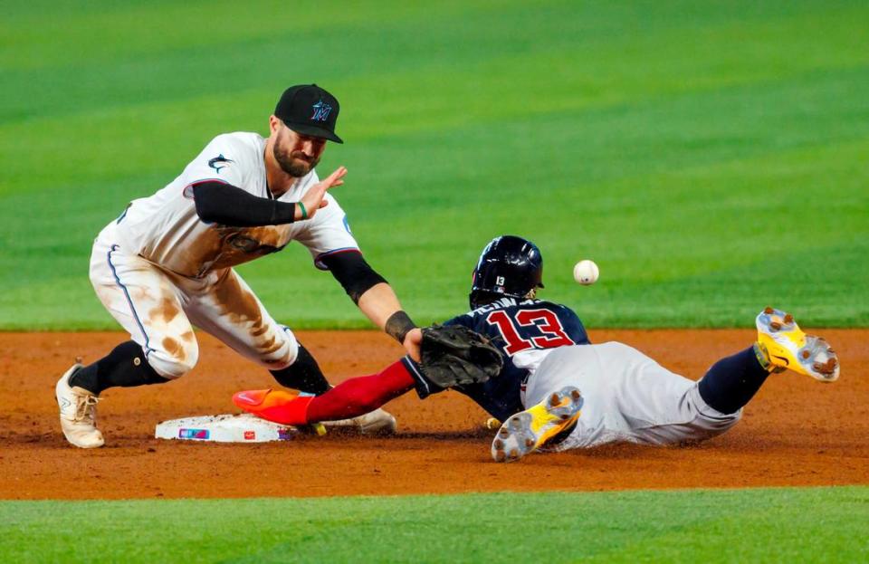 Miami Marlins shortstop Jon Berti (5) is unable to fields throw as Atlanta Braves right fielder Ronald Acuna Jr. (13) steals second during the second inning of a baseball game at loanDepot park on Thursday, May 4, 2023 in Miami, Florida.