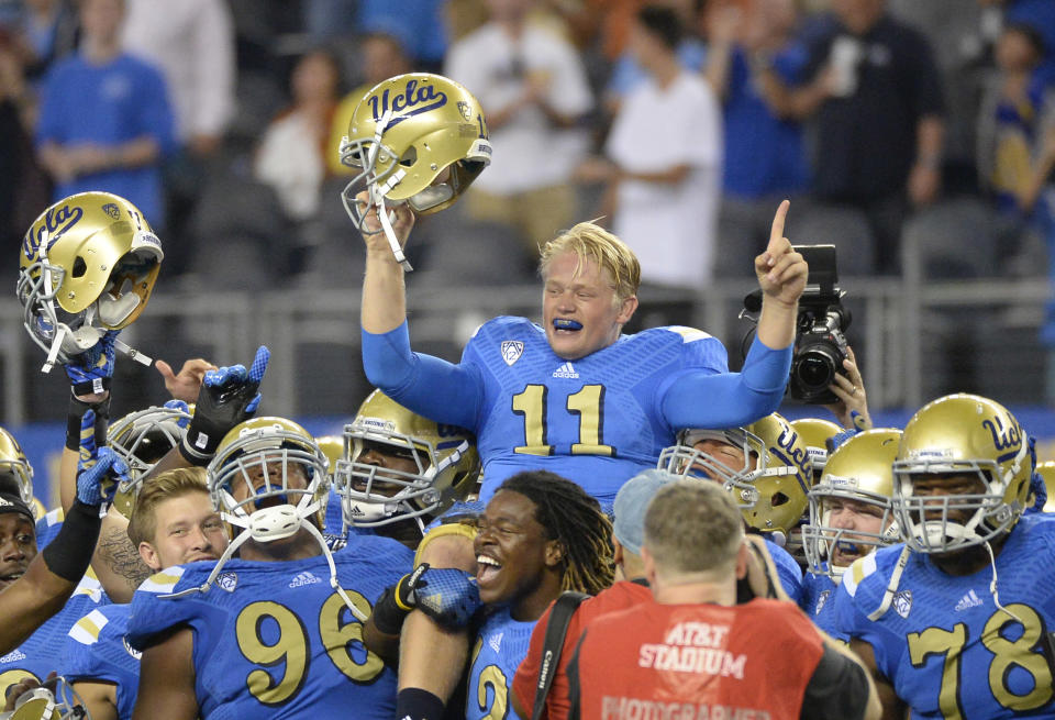 Sep 13, 2014; Arlington, TX, USA; The UCLA Bruins lift quarterback Jerry Neuheisel (11) after the end of the game at AT&T Stadium. UCLA beat Texas 20-17. (Richard Mackson-USA TODAY Sports)