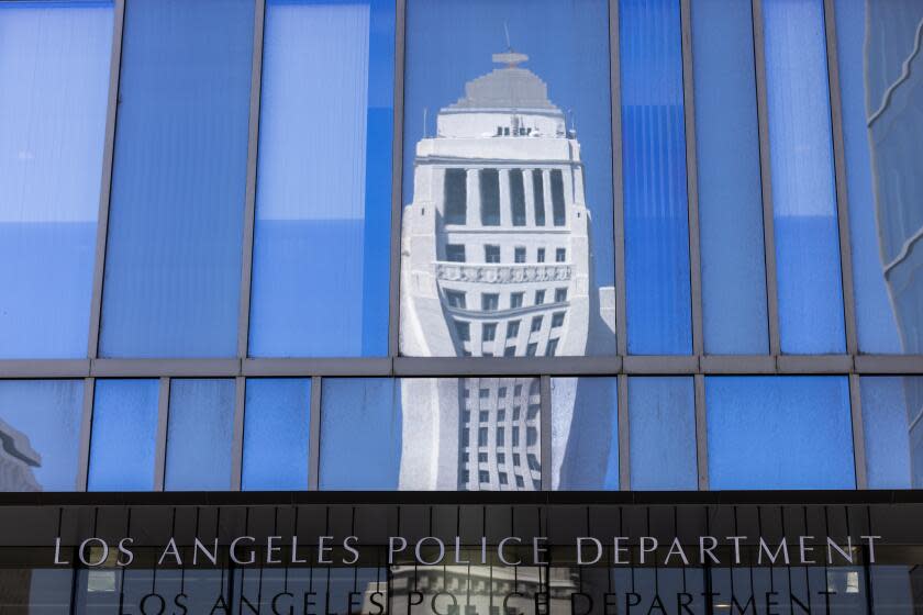 Los Angeles, CA - September 26: Los Angeles City Hall tower is reflected above the entrance to LAPD Headquarters in downtown Los Angeles on Tuesday, Sept. 26, 2023 in Los Angeles, CA. (Brian van der Brug / Los Angeles Times)