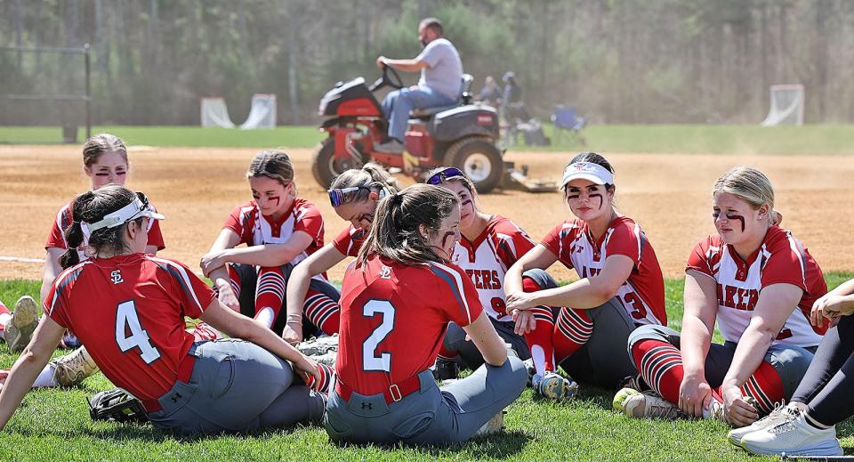 Silver Lake players rest off the field as repairs are made to the infield after a water leak. Silver Lake softball hosts Lincoln-Sudbury on Wednesday, April 17, 2024.