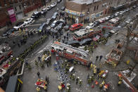 Firefighters work outside an apartment building after a fire in the Bronx, Sunday, Jan. 9, 2022, in New York. (AP Photo/Yuki Iwamura)