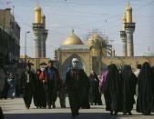 <b>BAGHDAD, IRAQ:</b> Iraqi Shia Muslims walk around the holy Kadhimiya mosque in Baghdad, Iraq. The Kadhimiya mosque is one of the main mosques for the Shia faith.