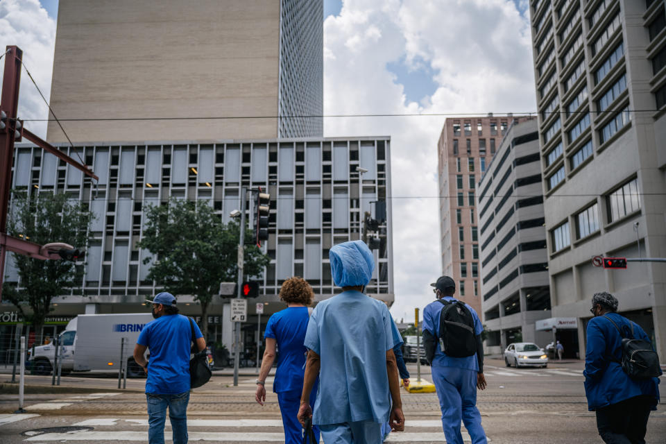 HOUSTON, TEXAS - JUNE 09: Medical workers and pedestrians cross an intersection outside of the Houston Methodist Hospital on June 09, 2021 in Houston, Texas. Houston Methodist Hospital has suspended 178 employees without pay for 14 days for their refusal to comply with its COVID-19 vaccine requirement. (Photo by Brandon Bell/Getty Images)