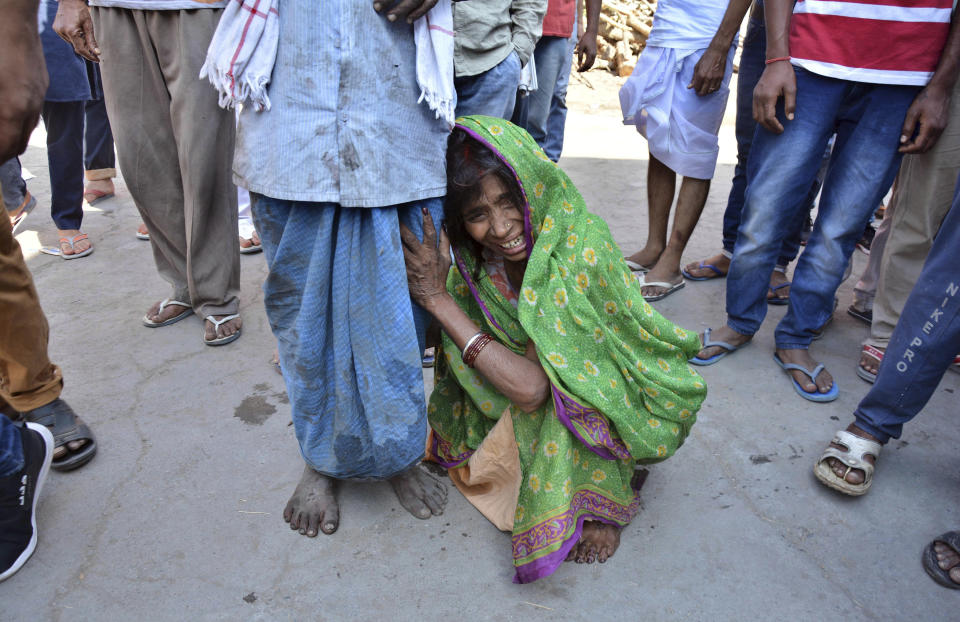 A woman cries holding on to her husband during the cremation of her son, who was killed in Friday's train accident, in Amritsar, India, Saturday, Oct. 20, 2018. A speeding train ran over a crowd watching fireworks during a religious festival in northern India on Friday evening, killing more than 50 people and injuring dozens more, police said. (AP Photo/Prabhjot Gill)