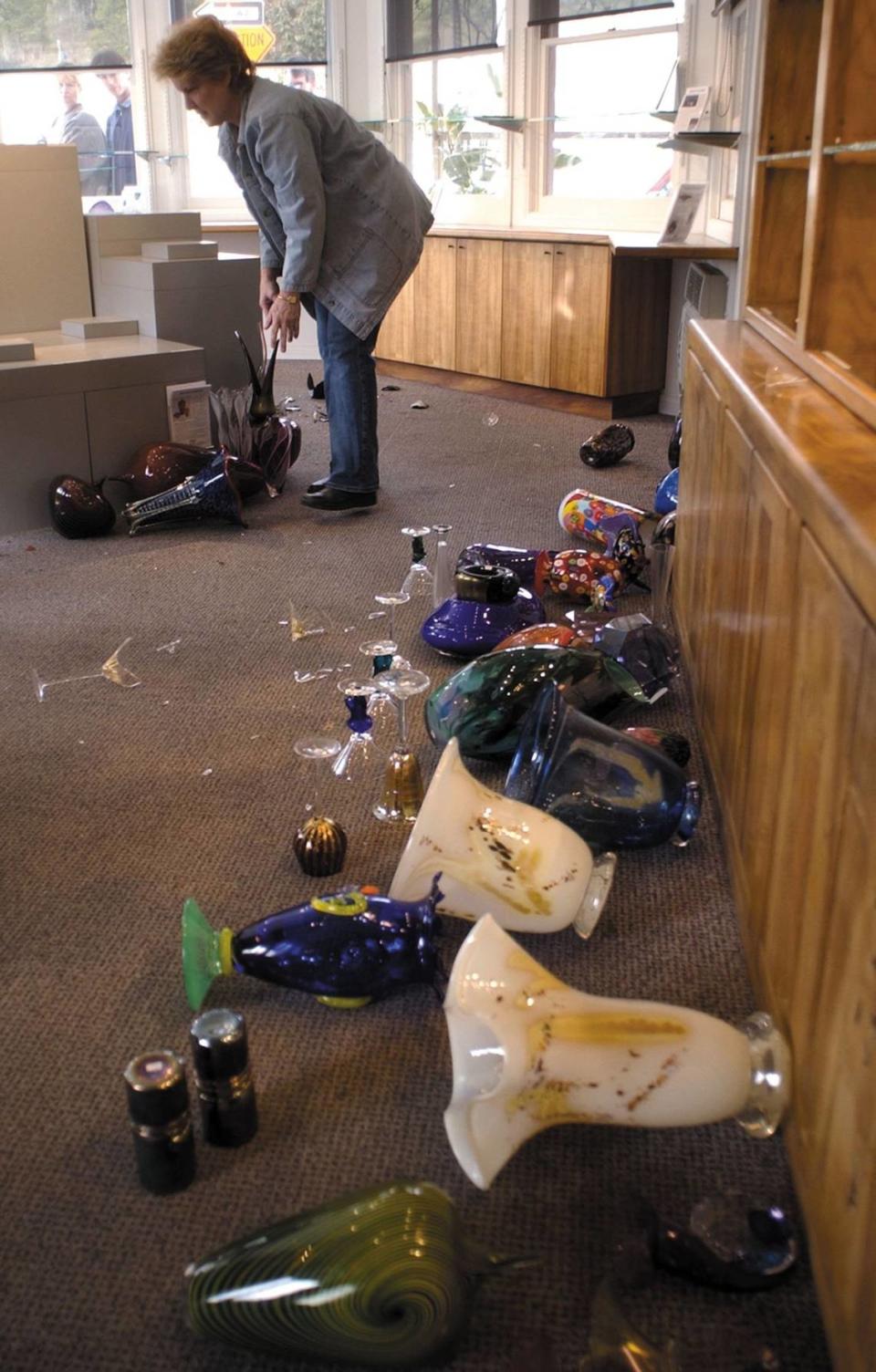 Maryel Elton, assistant manager at Seekers, an art gallery in Cambria, cleans up after thousands of dollars of art glass was damaged in a 6.5 magnitude earthquake Dec. 23, 2003.