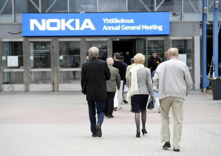 Varias personas llegan a una reunión general en la sede de la compañía de telecomunicaciones finlandesa Nokia, en Helsinki, el 23 de mayo de 2017. Foto: AFP. 