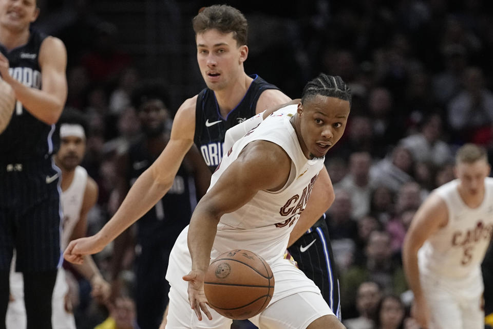 Cleveland Cavaliers forward Isaac Okoro, right, steals the ball from Orlando Magic Franz Wagner during the second half of an NBA basketball game Thursday, Feb. 22, 2024, in Cleveland. (AP Photo/Sue Ogrocki)