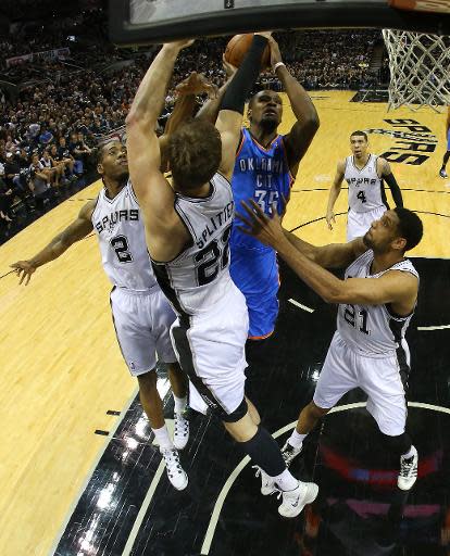 Kevin Durant, #35 de Oklahoma City Thunder, pelea el balon contra Kawhi Leonard #2, Tiago Splitter #22 y Tim Duncan #21, de San Antonio Spurs, en partido inicial de la serie final de la Conferencia Oeste de la NBA en el AT&T Center el 19 de mayo de 2014 en San Antonio, Texas. (GETTY IMAGES NORTH AMERICA/AFP | Ronald Martinez)