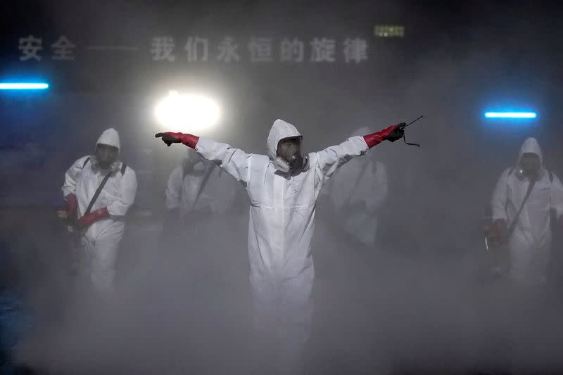 Volunteers from the Blue Sky Rescue team disinfect at the Qintai Grand Theatre in Wuhan