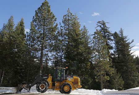 A Caltrans tractor clears some of the above-average snowfall along Highway 50 near the location of the first snow survey of winter conducted by the California Department of Water Resources in Phillips, California, December 30, 2015. REUTERS/Fred Greaves