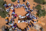 FILE - In this Thursday, April 30, 2020, file photo, medical workers in protective suits, accompanied by mourners, bury the body of an elderly man believed to have died of the coronavirus but whose family asked not to be named because of the social stigma, in Mogadishu, Somalia. A dangerous stigma has sprung up around the coronavirus in Africa — fueled, in part, by severe quarantine rules in some countries as well as insufficient information about the virus. (AP Photo/File)