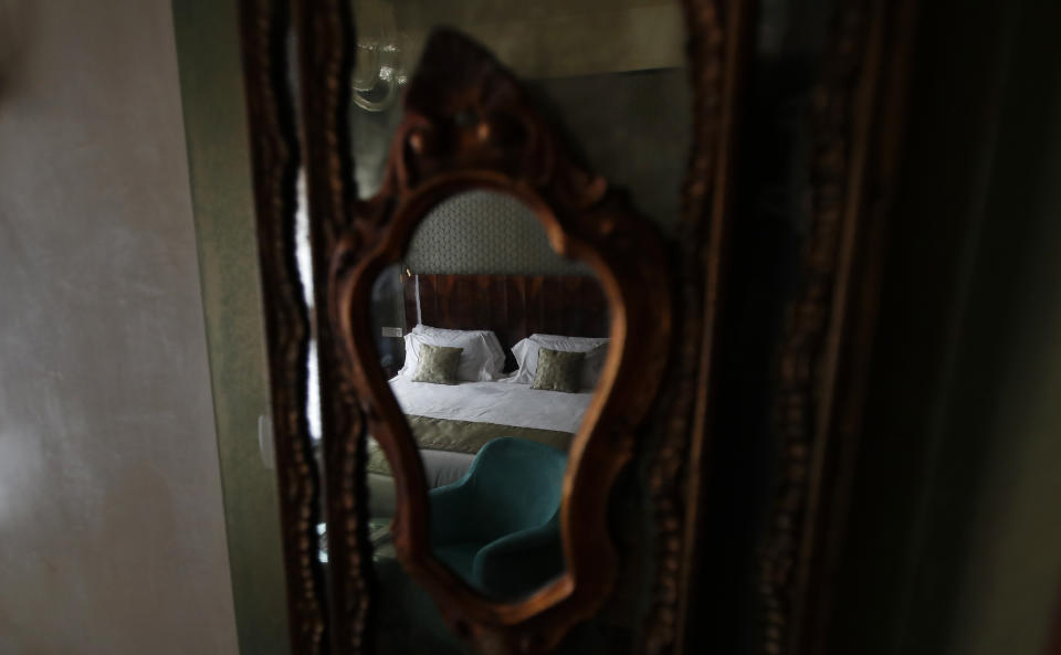 In this picture taken on Wednesday, May 13, 2020 a bed is reflected in the mirror in a bedroom of the Saturnia hotel, founded in 1908, in Venice, Italy. The hotel is currently closed to the public after lockdown measures to prevent the spread of COVID-19 brought national and International leisure travel to a halt, (AP Photo/Antonio Calanni)