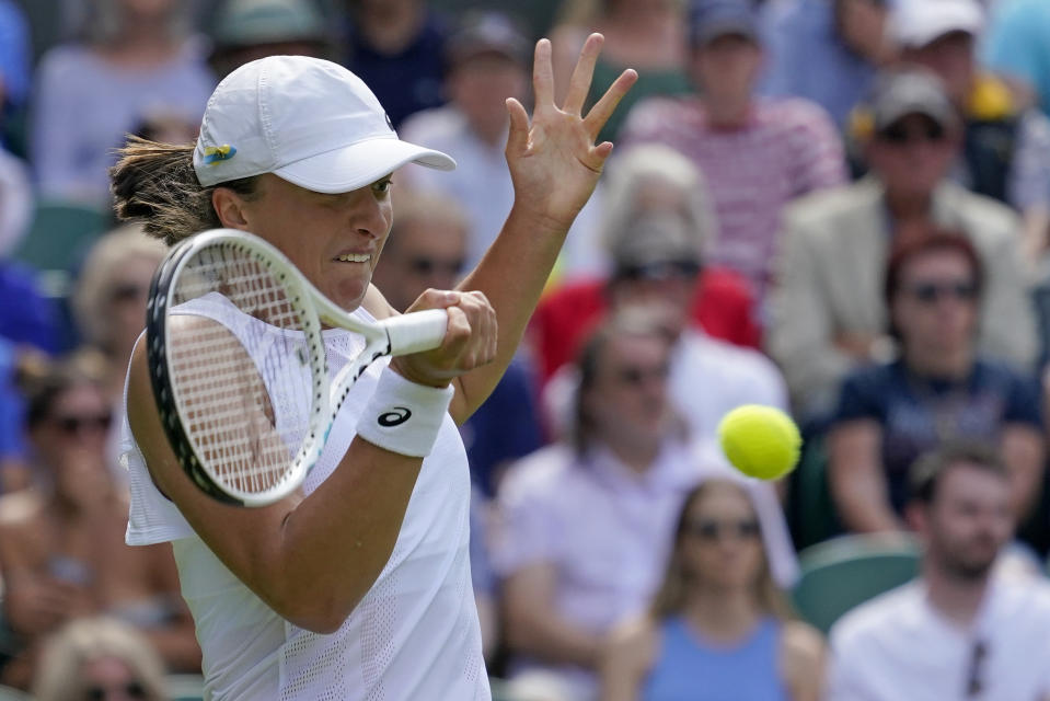 Poland's Iga Swiatek returns to Croatia's Jana Fett in a first round women's singles match on day two of the Wimbledon tennis championships in London, Tuesday, June 28, 2022. (AP Photo/Alberto Pezzali)