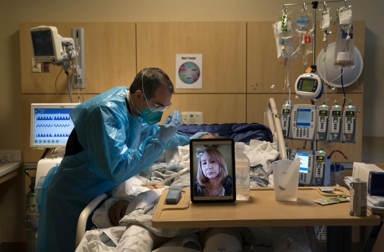 <span class="caption">A chaplain prays for a COVID-19 patient in Los Angeles while on a video call with the patient's daughter in November 2020.</span> <span class="attribution"><a class="link " href="https://newsroom.ap.org/detail/APTOPIXVirusOutbreakCalifornia/d120b3fd64064c77b02ec1c3bd5b9a5d/photo?Query=chaplains%20%20covid&mediaType=photo&sortBy=&dateRange=Anytime&totalCount=76&currentItemNo=35" rel="nofollow noopener" target="_blank" data-ylk="slk:AP Photo/Jae C. Hong;elm:context_link;itc:0;sec:content-canvas">AP Photo/Jae C. Hong</a></span>
