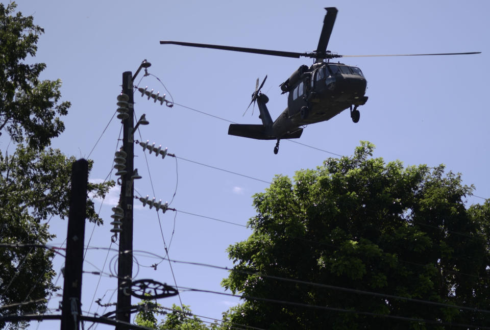 A US military helicopter takes off while US army reserves sets up tents for portable showers at a tent city for hundreds of people displaced by earthquakes in Guanica, Puerto Rico, Tuesday, Jan. 14, 2020. A 6.4 magnitude quake that toppled or damaged hundreds of homes in southwestern Puerto Rico is raising concerns about where displaced families will live, while the island still struggles to rebuild from Hurricane Maria two years ago. (AP Photo/Carlos Giusti)