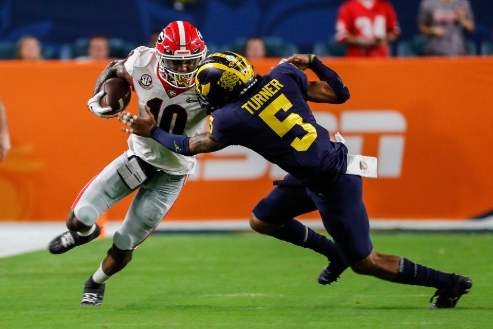 Michigan defensive back DJ Turner (5) tackles Georgia wide receiver Kearis Jackson (10) during the first half of the Orange Bowl at the Hard Rock Stadium in Miami, Fla. on Friday, Dec. 31, 2021.