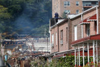 <p>A man watches emergency service personnel work at the scene of a house explosion from a roof, Tuesday, Sept. 27, 2016, in the Bronx borough of New York. (AP Photo/Mary Altaffer) </p>