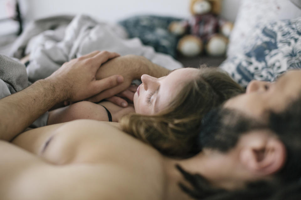 a couple lying with one another in bed