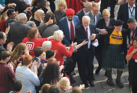 A supporter wearing a kilt is coaxed to one side after approaching Britain's opposition Labour Party Leader Jeremy Corbyn as he arrives to deliver his keynote speech at the Labour Party Conference in Brighton, Britain, September 27, 2017. REUTERS/Toby Melville