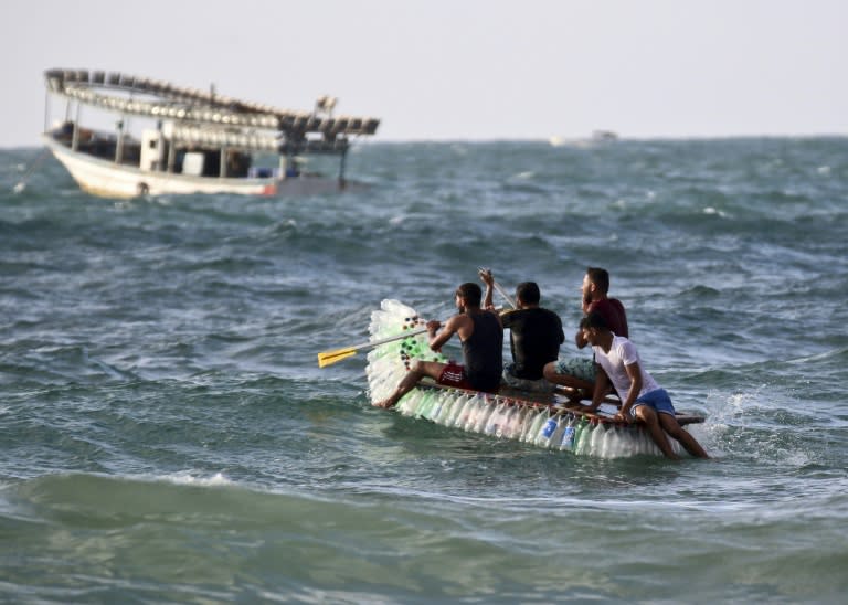 Palestinian fisherman Mouad Abu Zeid and his friends ride his boat in the sea of Rafah in the southern Gaza Strip on August 14, 2018