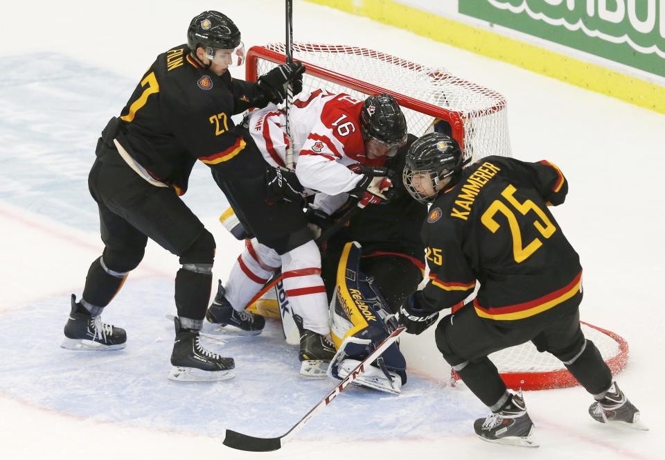 Canada's Rychel is pushed into Germany's goalie Cupper by Germany's Filin during the third period of their IIHF World Junior Championship ice hockey game in Malmo