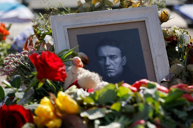 Flowers are left next to a photo of the late Russian opposition leader Alexei Navalny at a makeshift memorial in front of the Russian Embassy in Berlin on March 19, 2024. Yulia Navalnaya, the widow of Kremlin foe Alexei Navalny, called on Russians who oppose President Vladimir Putin "not to give up", on March 19, 2024 while dismissing Moscow's election result as having "no meaning". (David GANNON)