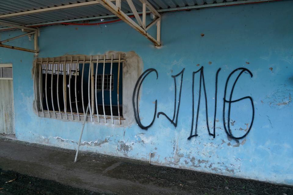 The letters CJNG for the group's formal name, Jalisco New Generation Cartel, is scrawled on the facade of an abandoned home, in El Limoncito, in the Michoacán state of Mexico, Saturday, Oct. 30, 2021. The cartel based in Jalisco state is spreading into neighboring Michoacán.