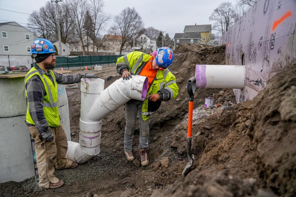 Apprentice plumber Devyn Maher and foreman Russell Michaud install pipes for a storm drainage system at the site of the new Elizabeth Baldwin Elementary School in Pawtucket. Maher has also worked on Brown University's Lindemann Performing Arts Center, a pharmaceutical lab in South Providence and the Amazon Fulfillment Center in Johnston.